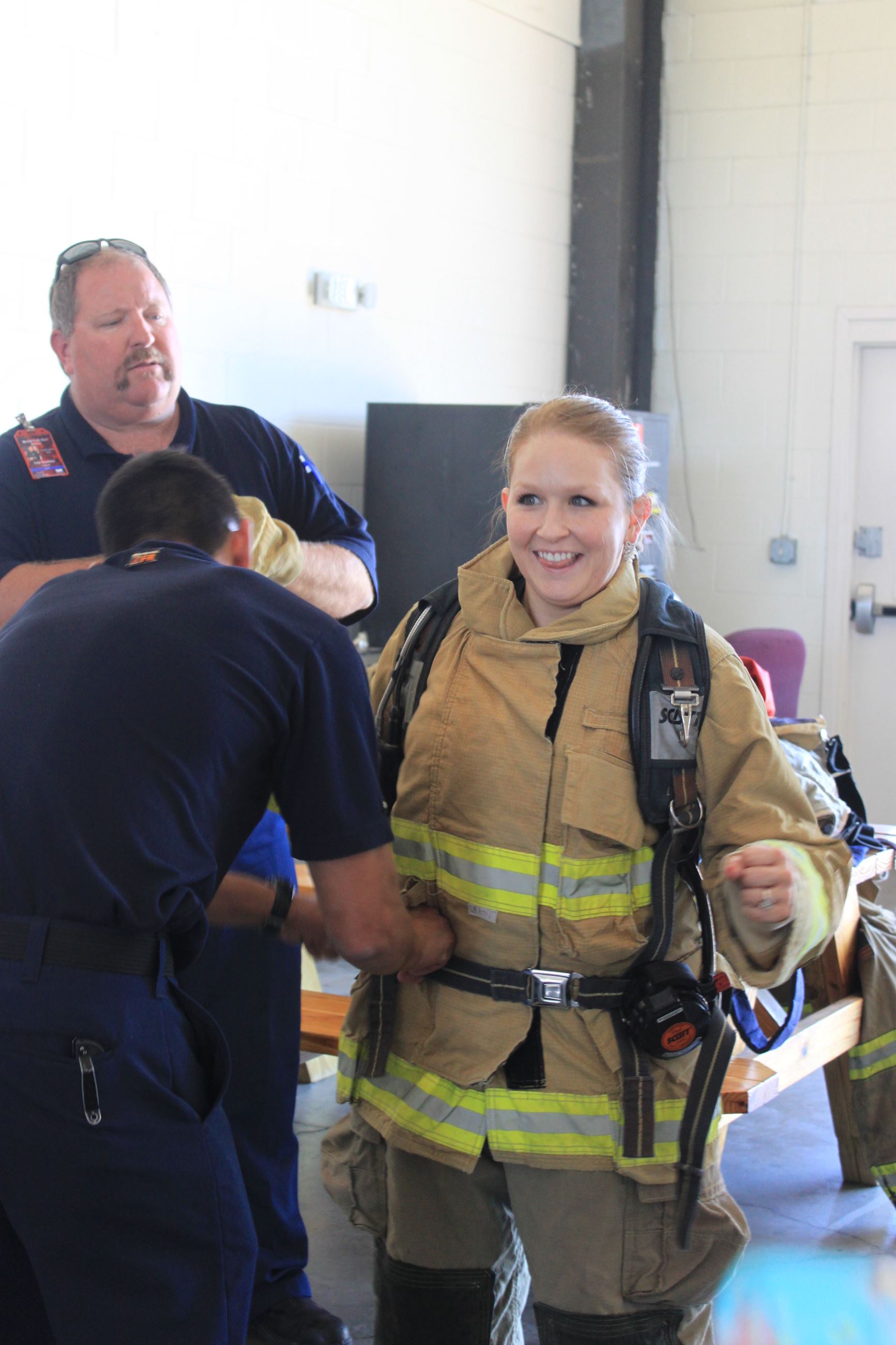 Firefighters put firefighting equipment on a person