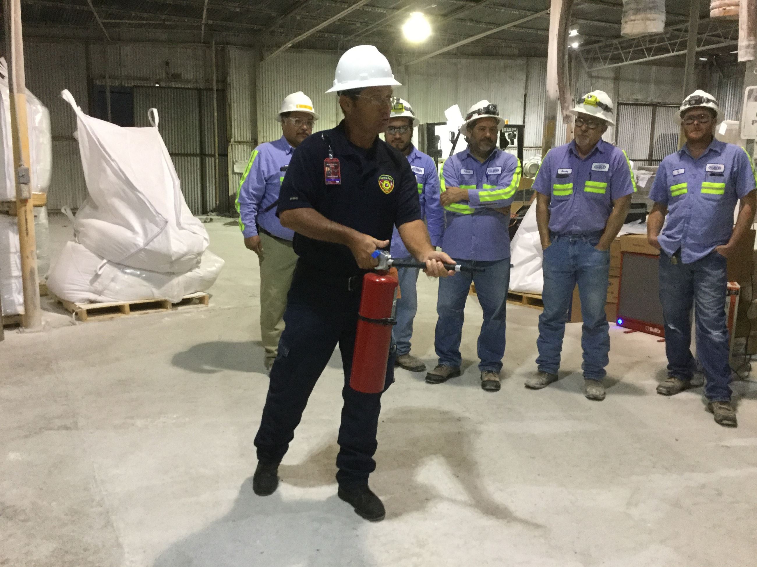 A firefighter demonstrates using a fire extinguisher