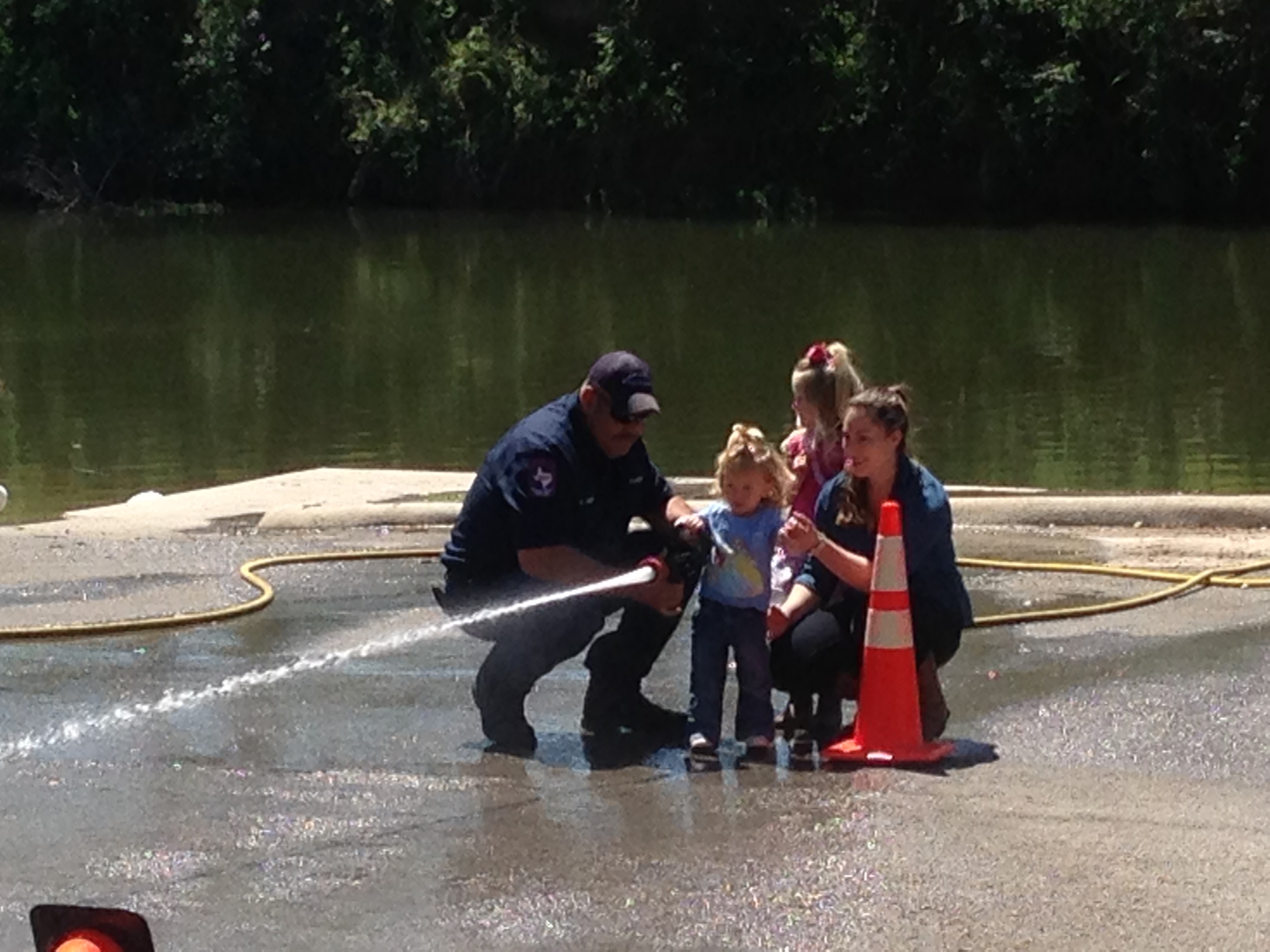 A small child uses a fire hose